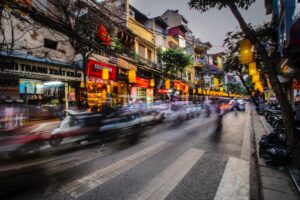 A photo with a tripod that captures a long exposure of a busy street, creating a sense of motion